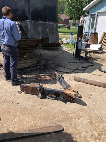 Image d'une personne travaillant sur un projet de soudure en plein air chez Réparation et Fabrication Gagné.