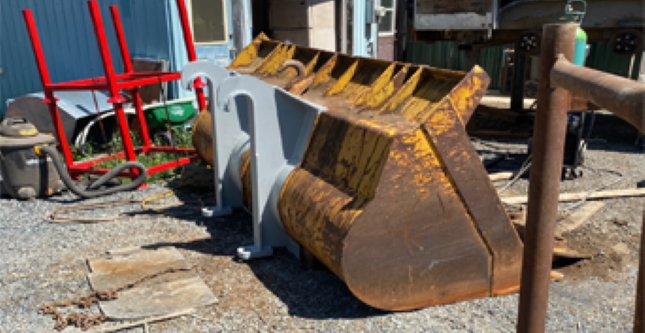 Image d'une pièce de godet d'excavatrice réparée ou en cours de modification chez Réparation et Fabrication Gagné.